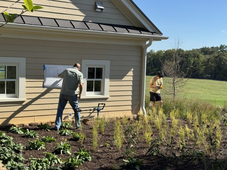 Crew mounting equipment on the siding of a country home